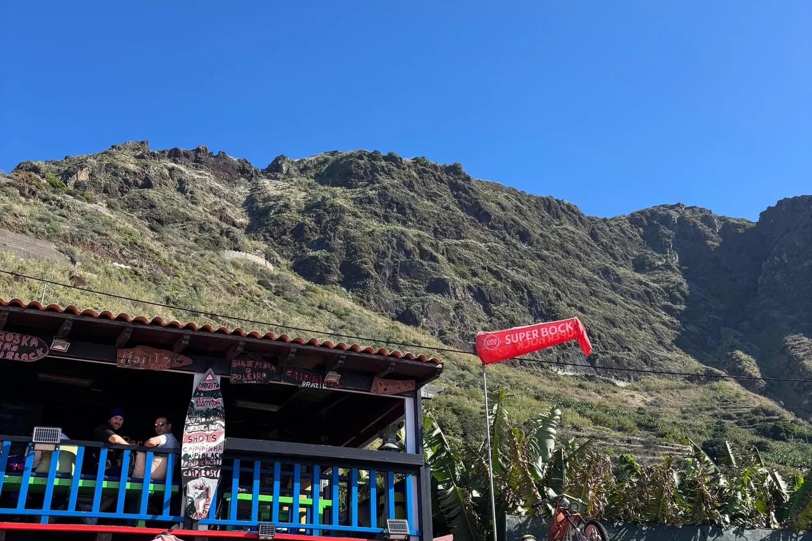 Colourful cliffside beach bar beneath the towering coastal cliffs
